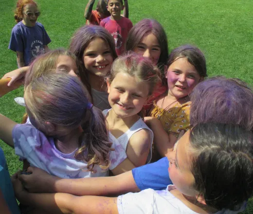 Huddle of campers covered in colored powder after running a race